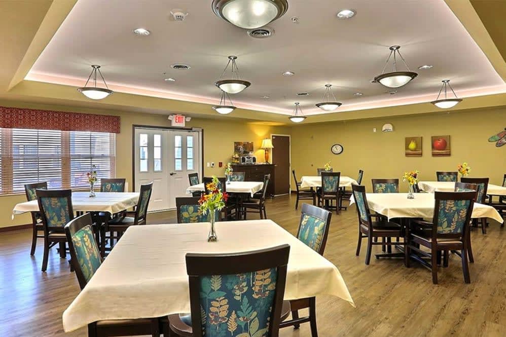 A well-lit dining room with neatly arranged tables and chairs.