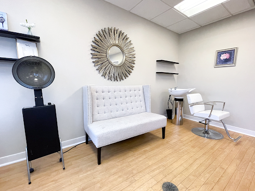 A stylish and modern waiting area in a hair salon, featuring elegant furniture and minimalist decor.