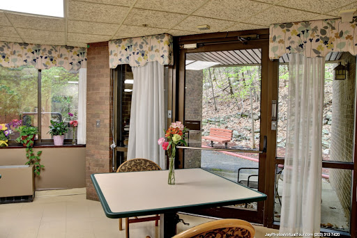 A cozy interior space with a table adorned with flowers and natural light streaming through the window.