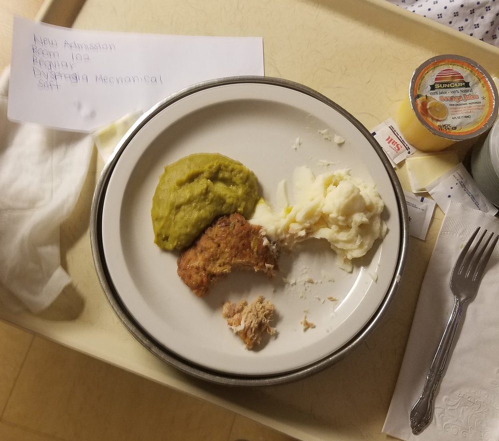 A hospital meal tray featuring mashed potatoes, meatloaf, and peas.