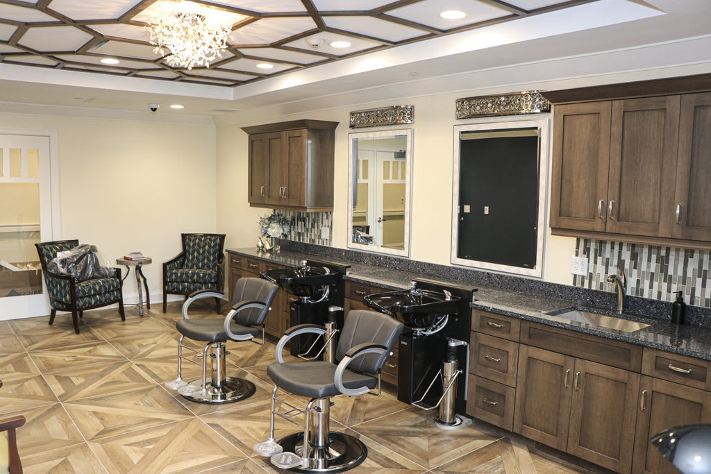 A modern hair salon interior with stylish chairs, mirrors, and wooden furnishings.