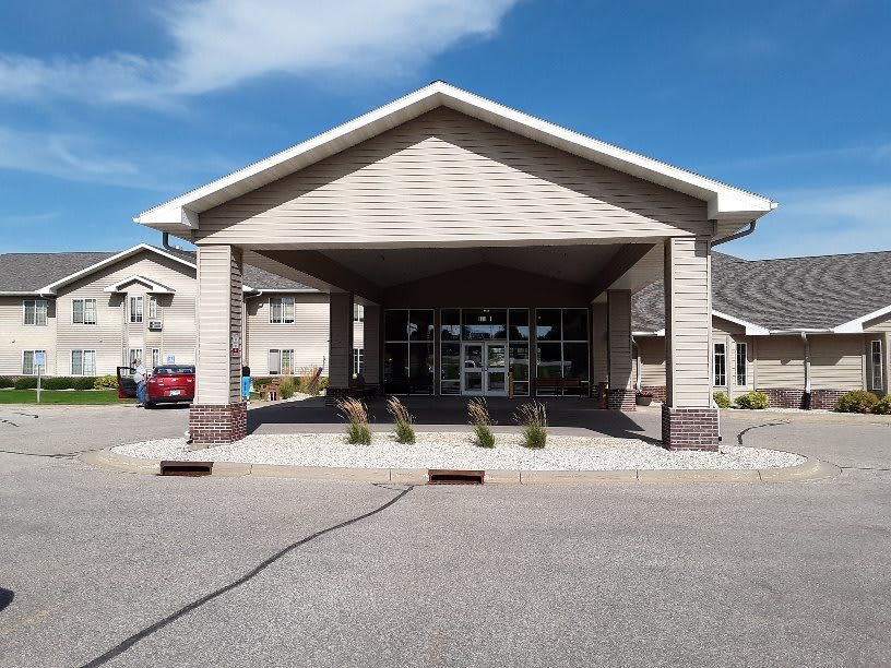 A building with a large covered entrance and clear skies.