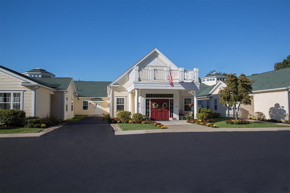A suburban residential house with a driveway under a clear blue sky.