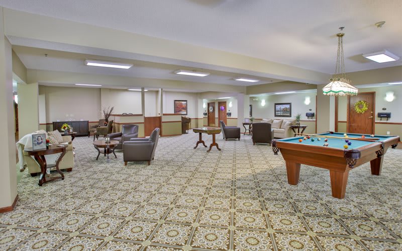 Spacious lounge area with seating and a pool table.