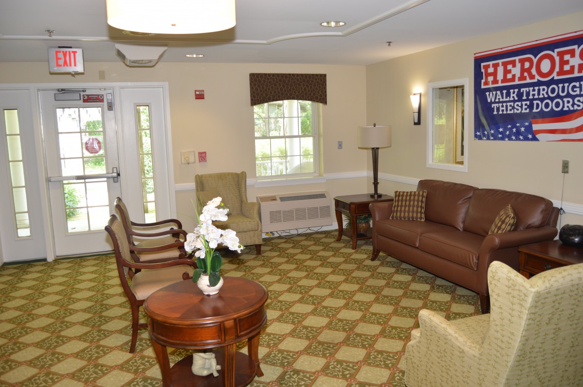 A cozy waiting area with comfortable seating, featuring a sofa, chairs, and a coffee table in a warmly decorated living room.