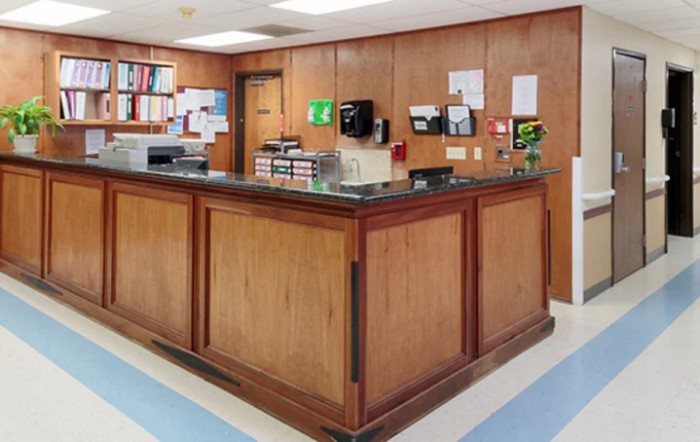 An office reception area with wood paneling and a central desk.