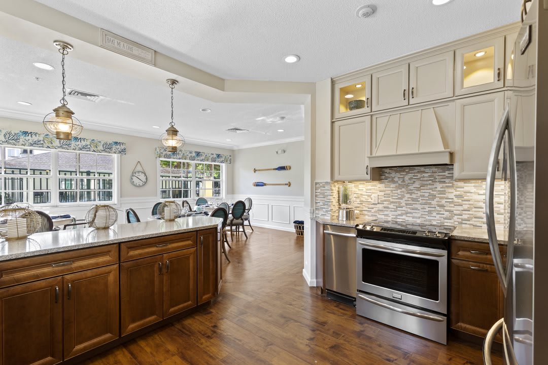 A modern kitchen with stainless steel appliances, hardwood floors, and an open concept dining area.