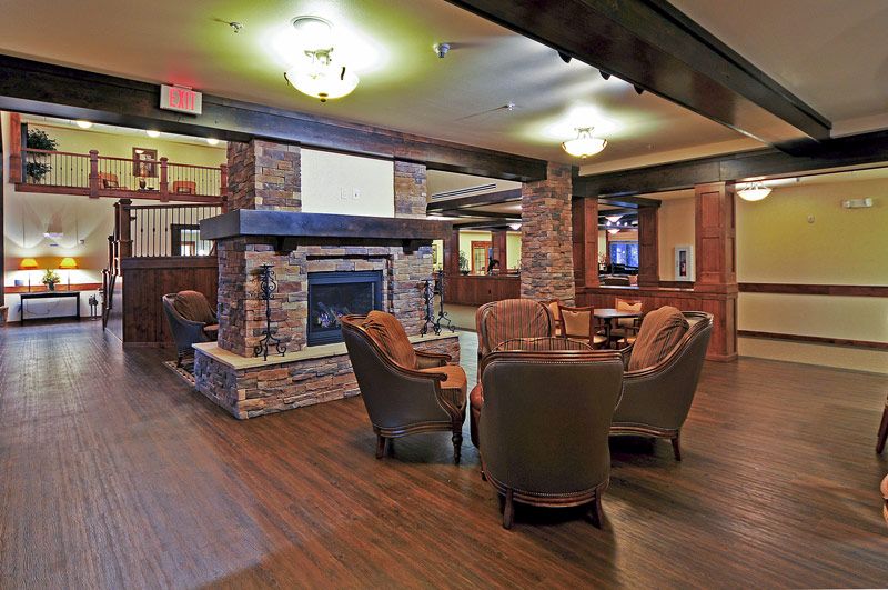 A cozy lounge area featuring a stone fireplace and comfortable seating.