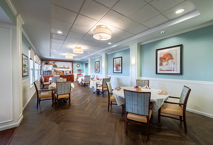 A cozy restaurant dining area with elegantly arranged tables and chairs, complemented by tasteful decor and soft lighting.