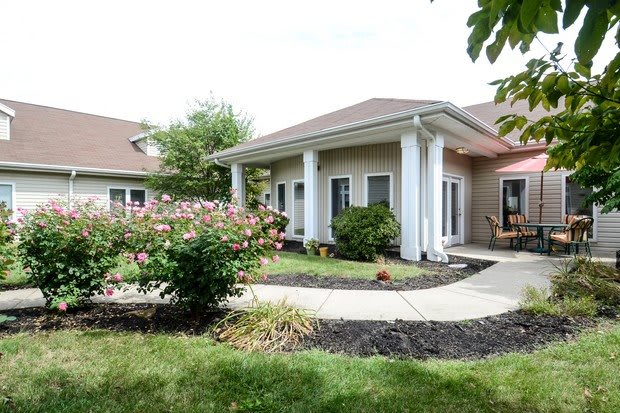 A well-maintained house with a garden and white columns.