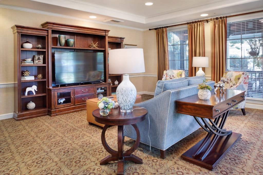 A cozy living room with elegant furnishings, featuring a large television, comfortable sofa, and decorative accents.