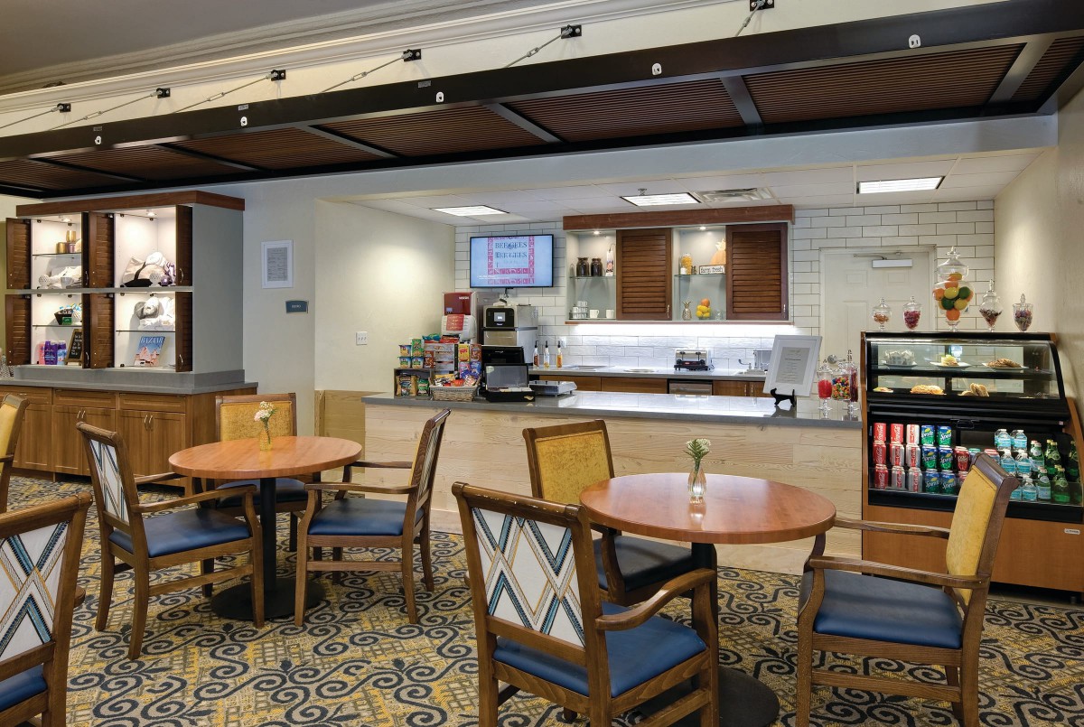 A cozy cafe seating area with tables, chairs, and a coffee station.