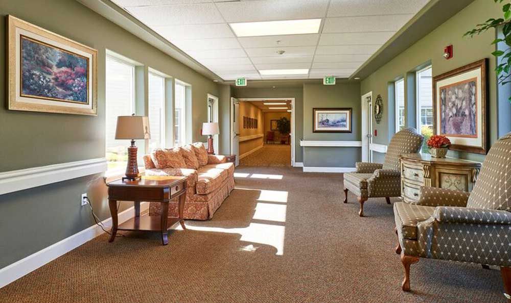 A spacious and well-lit hallway with comfortable seating and large windows.