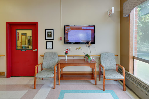 A cozy waiting room featuring comfortable chairs and a television.