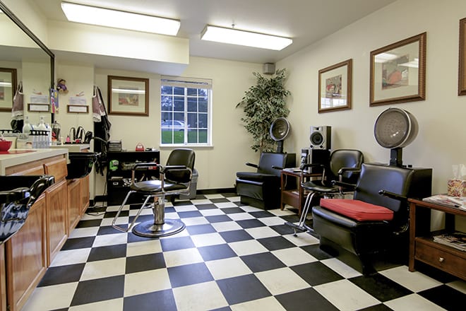 A cozy barber shop with a checkered floor design, comfortable chairs, and stylish decor.