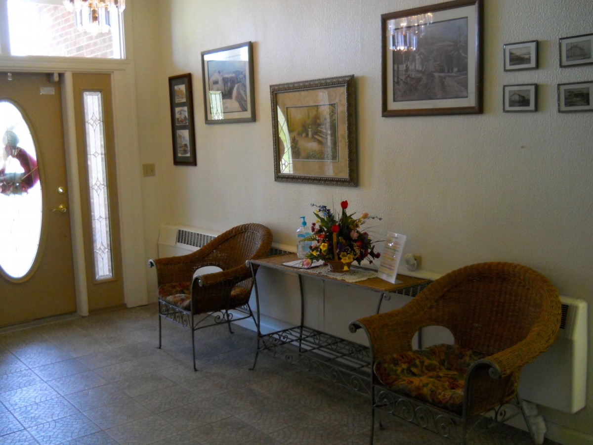 A cozy waiting room with chairs, artwork on the walls, and decorative pieces on a table.
