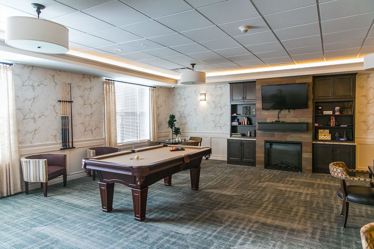 A modern game room featuring a pool table and entertainment setup.