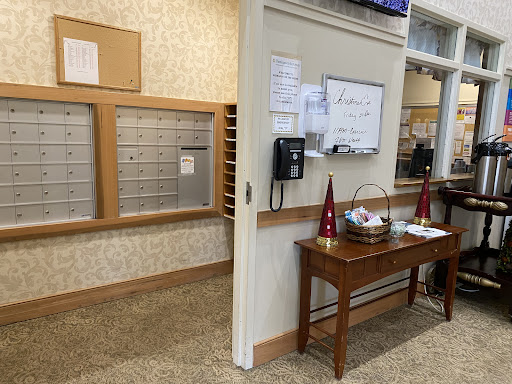 A view of a reception area featuring mailboxes, a phone, and a decorative table.