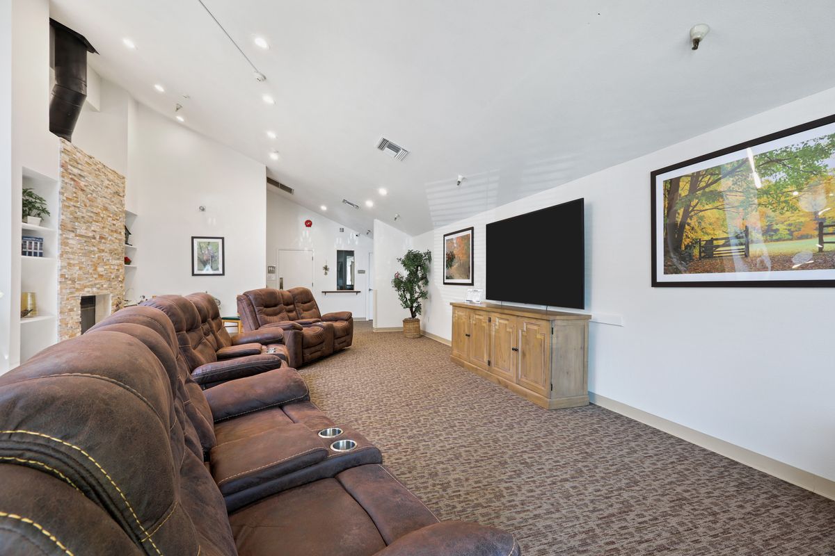 A cozy home theater room with plush recliner chairs and a large screen, perfect for movie nights.