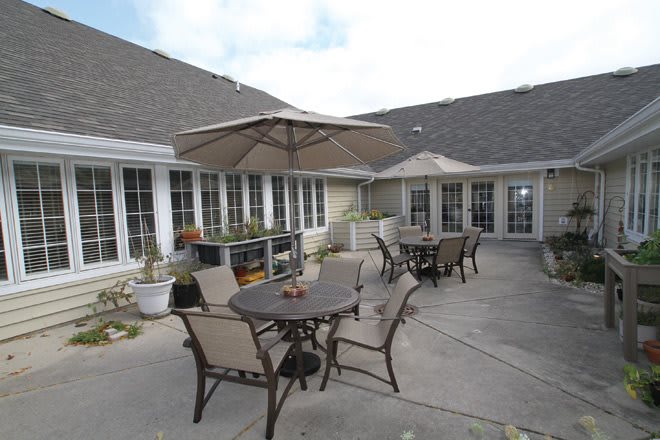 A spacious outdoor patio area featuring tables with umbrellas and chairs.