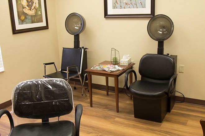 A cozy salon interior with seating and hair dryers.