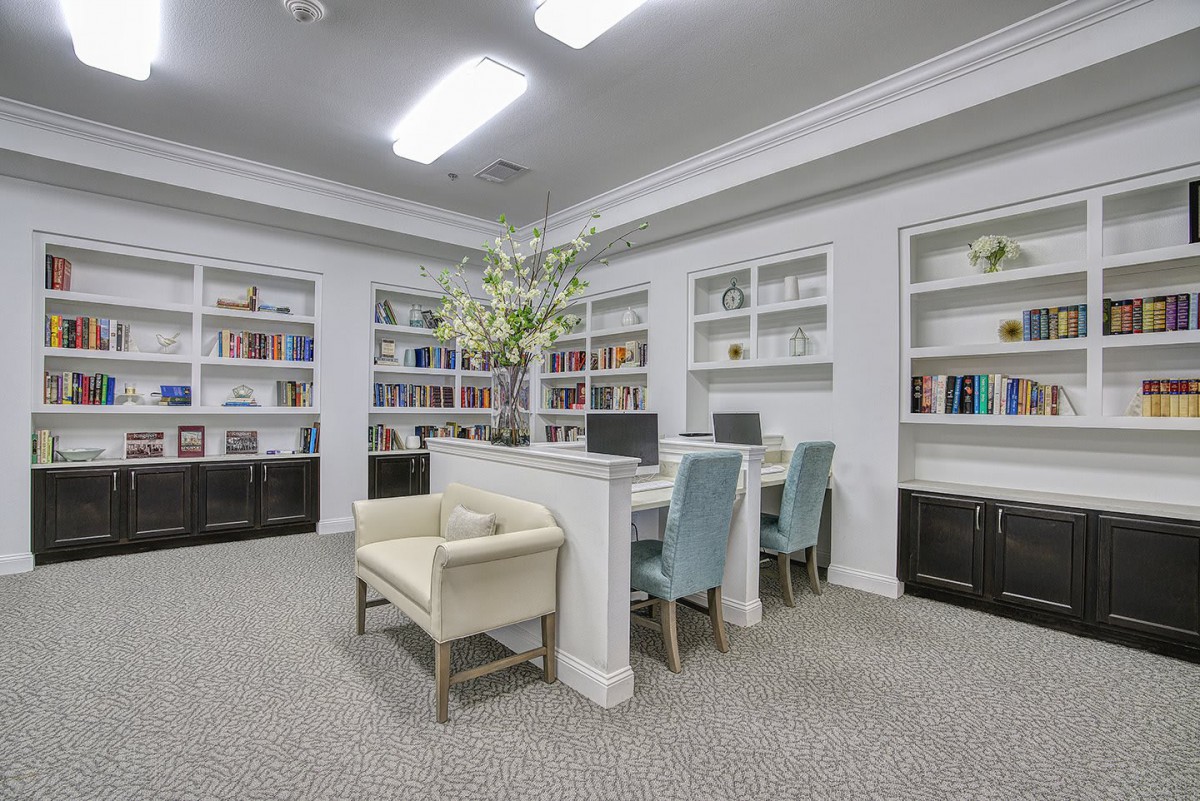 A modern library interior with bookshelves, a reading area, and computers.