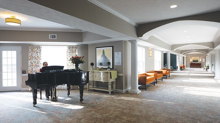 A modern lobby with a grand piano, stylish seating, and contemporary artwork.
