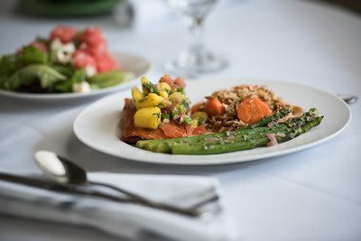 A beautifully arranged plate featuring a healthy mix of vegetables and grains, with asparagus in the foreground.