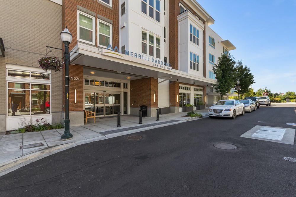 A modern residential building with a car parked on the street.