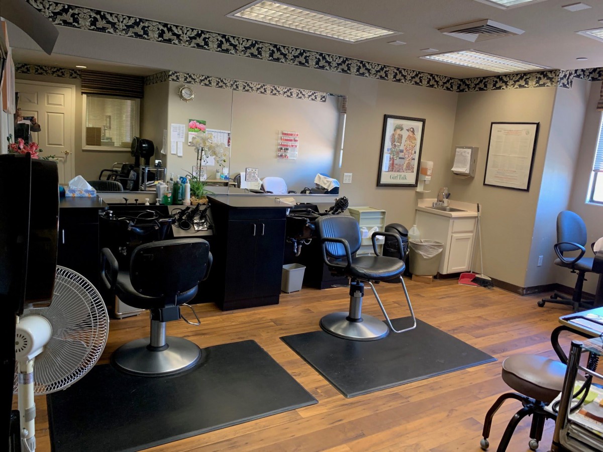 Interior of a barber shop with haircut stations and chairs.