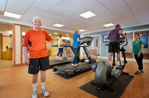 A group of seniors engaging in exercise at a gym, focusing on maintaining fitness and health.