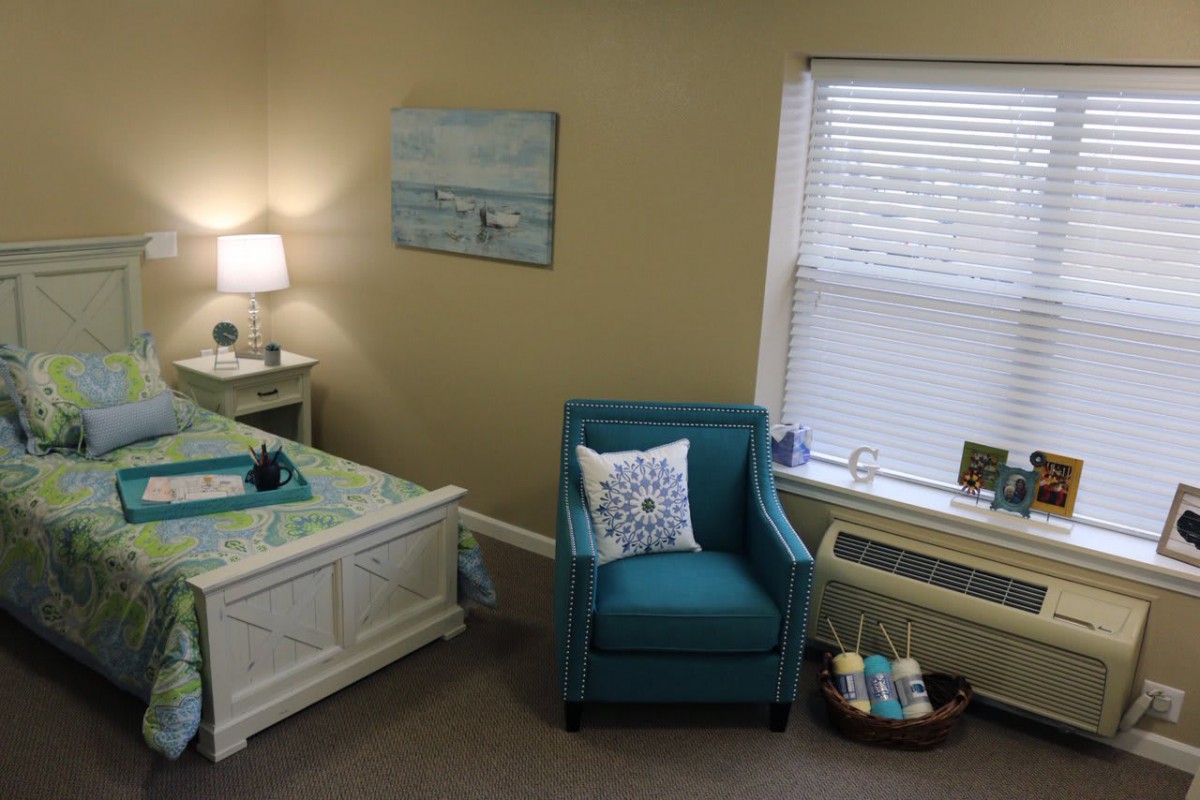 Cozy bedroom with a teal chair and stylish decor.