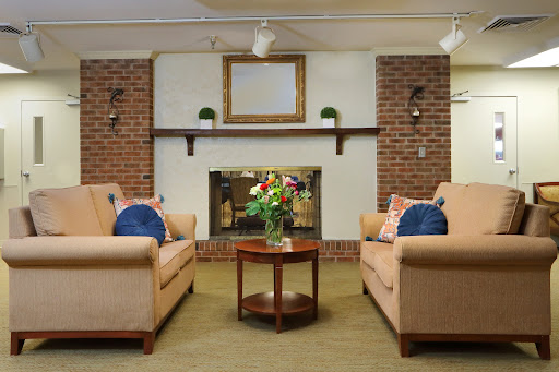 A cozy living room featuring comfortable sofas, a central coffee table, and a decorative fireplace.