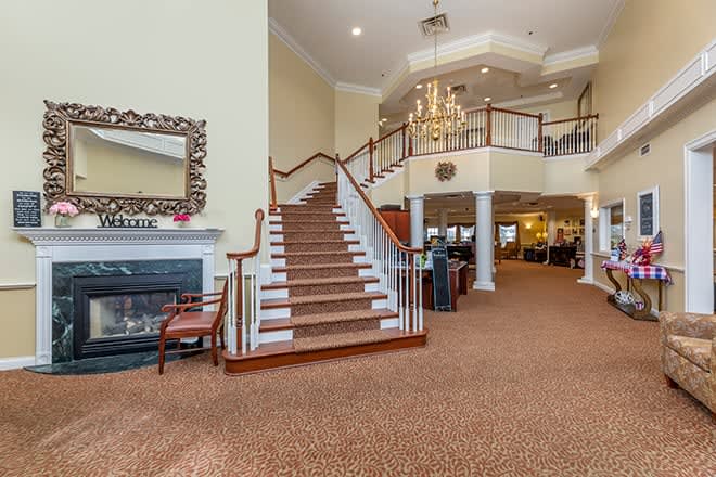 Elegant lobby with a grand staircase and chandelier.