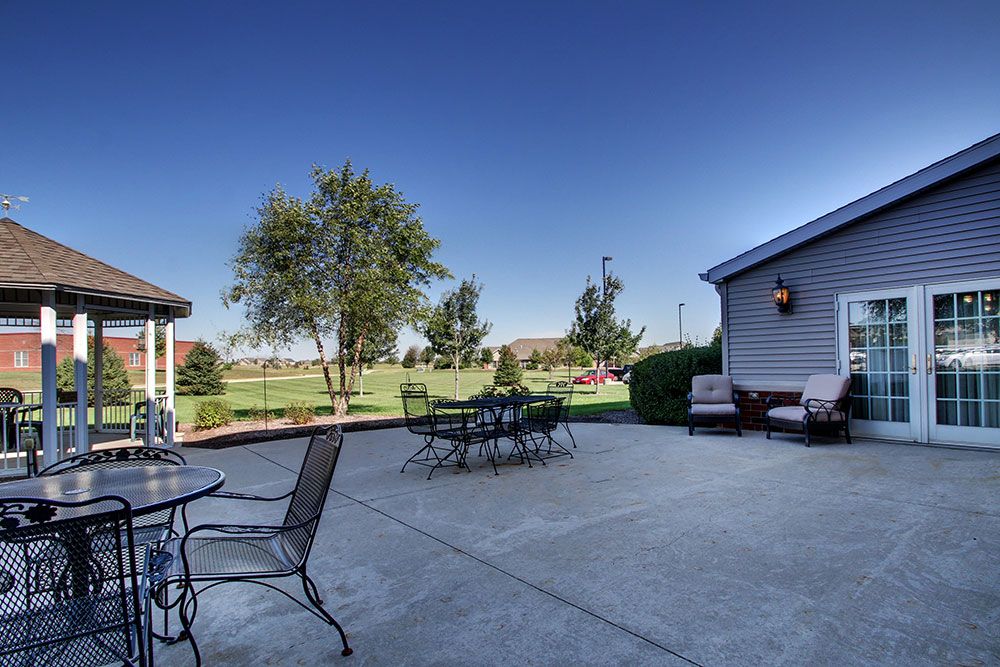 A spacious outdoor patio with seating and a view of the garden.