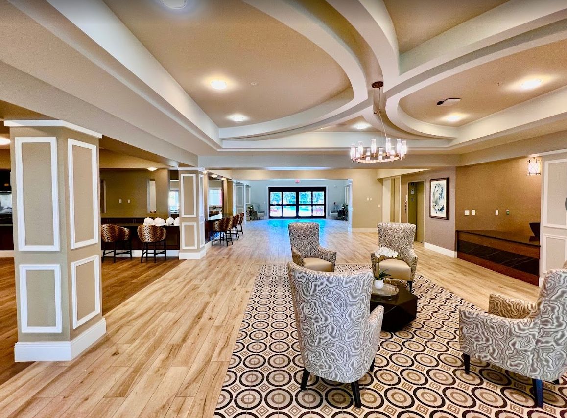 A spacious and elegantly designed lounge area with comfortable seating and intricate ceiling details.
