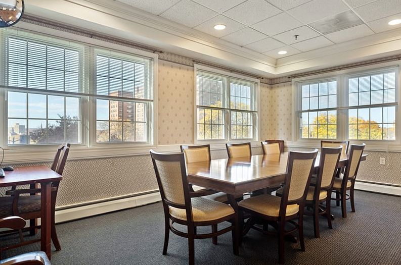 A well-lit conference room with a long meeting table and chairs.