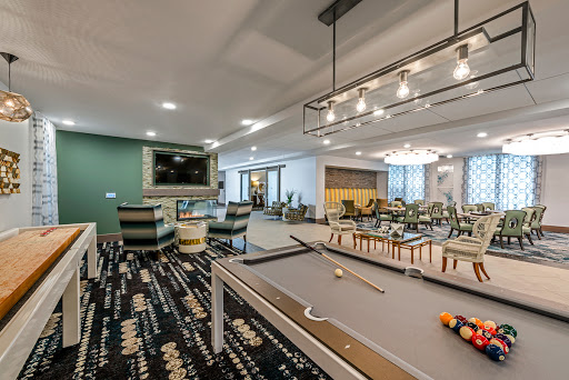 A stylish recreational room featuring a pool table and a comfortable lounge area.