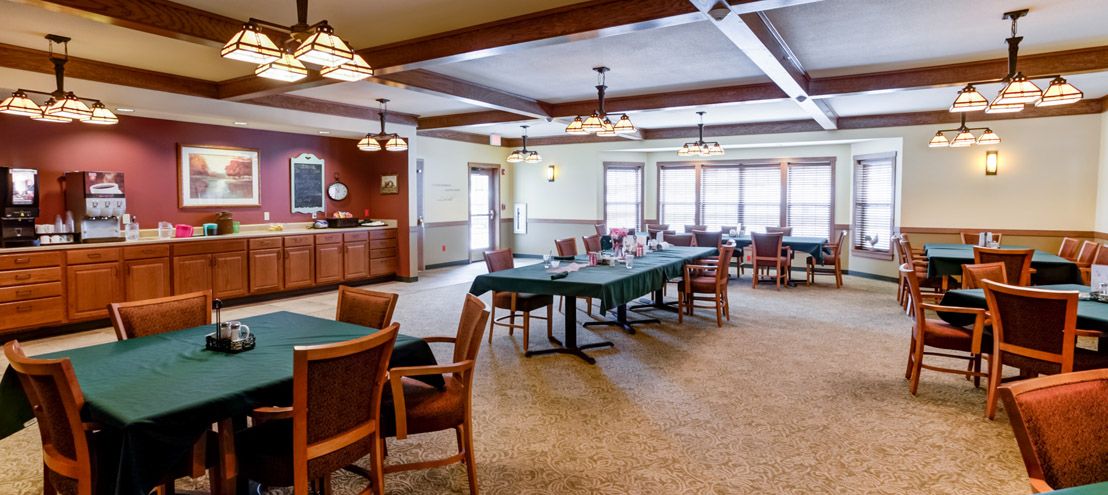 A spacious dining area with neatly arranged tables and chairs, well-lit by overhead fixtures.