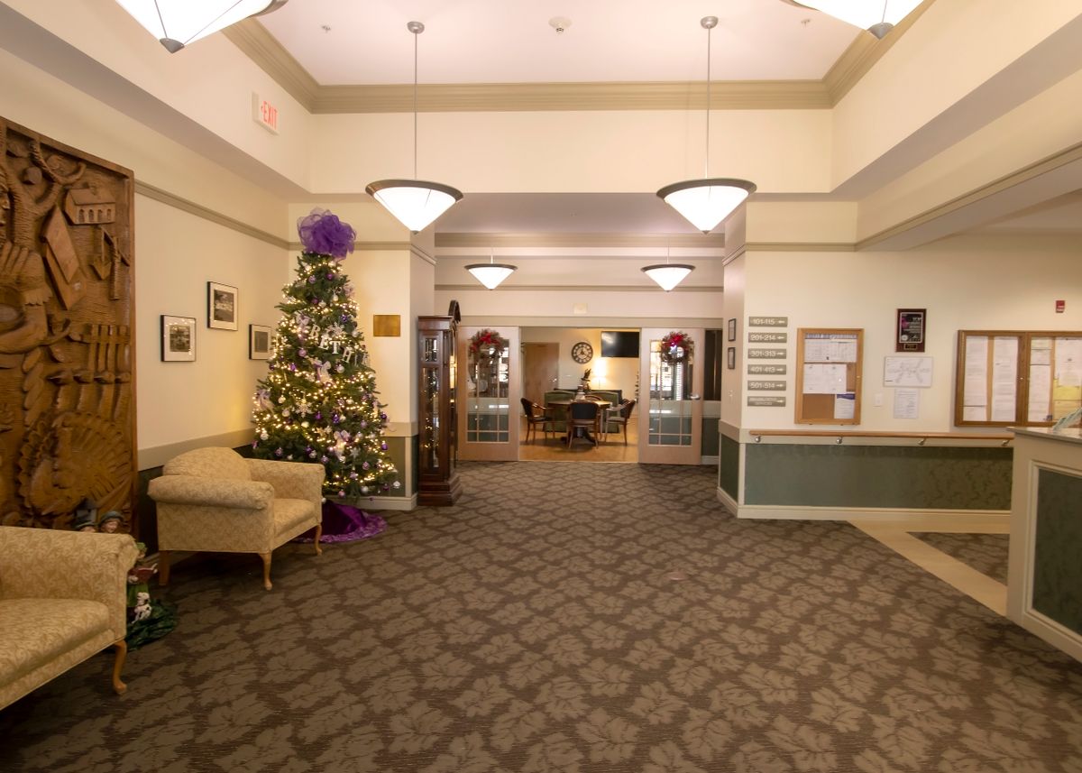 A cozy living room decorated for the holiday season with a Christmas tree and festive ornaments.