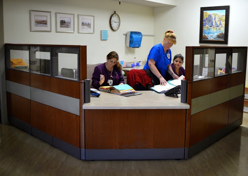 Healthcare reception area with staff attending to paperwork.