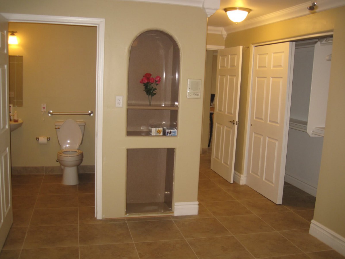 A view of a hallway with a bathroom and closet doors.