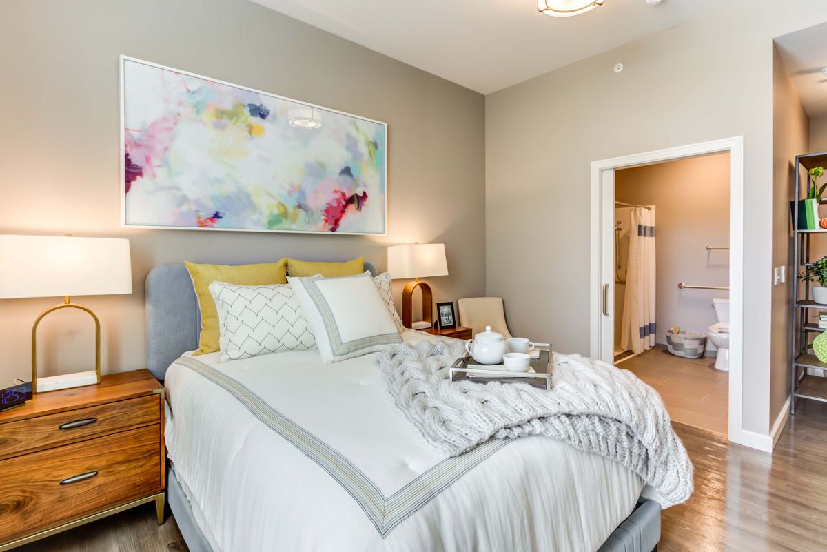 A cozy and modern bedroom with stylish decor and art.