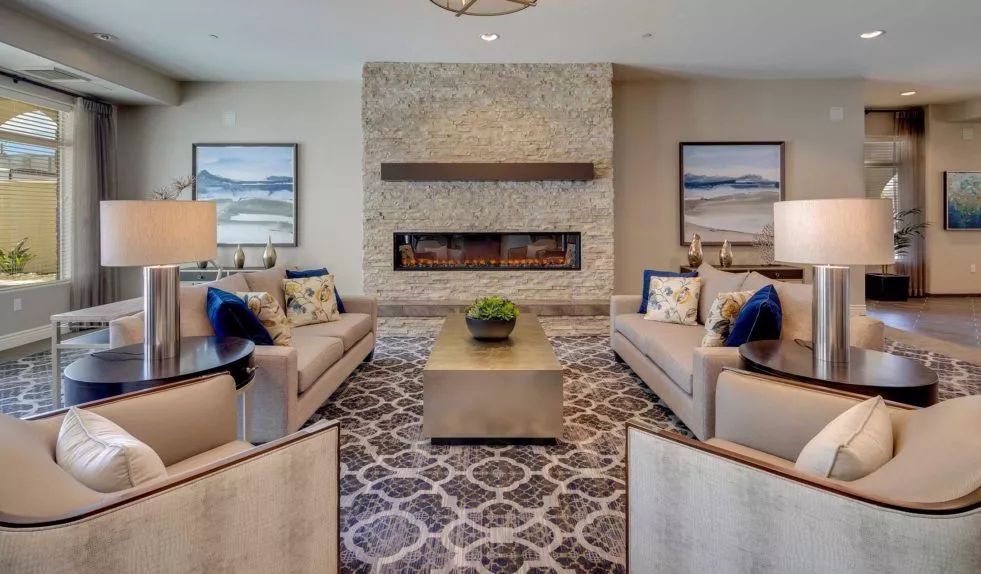 A stylish living room featuring a stone fireplace, modern sofas, and elegant decor.