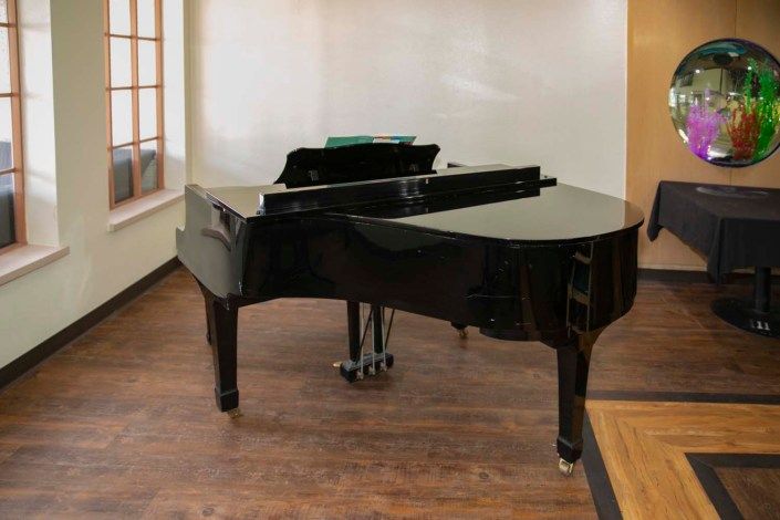 A grand piano placed in a music room.