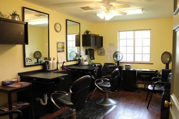 A well-lit hair salon interior with styling stations and chairs.