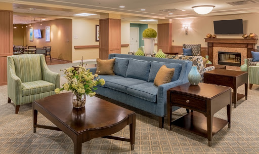 A cozy and inviting lobby area featuring a blue sofa, wooden coffee table, and decorative plants.