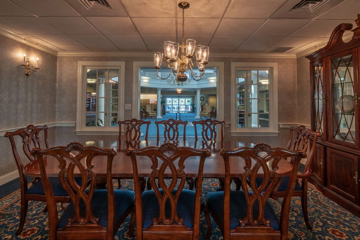 A traditional dining room with a large wooden table and an elegant chandelier.