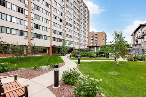 A modern apartment building with landscaped gardens and pathways.