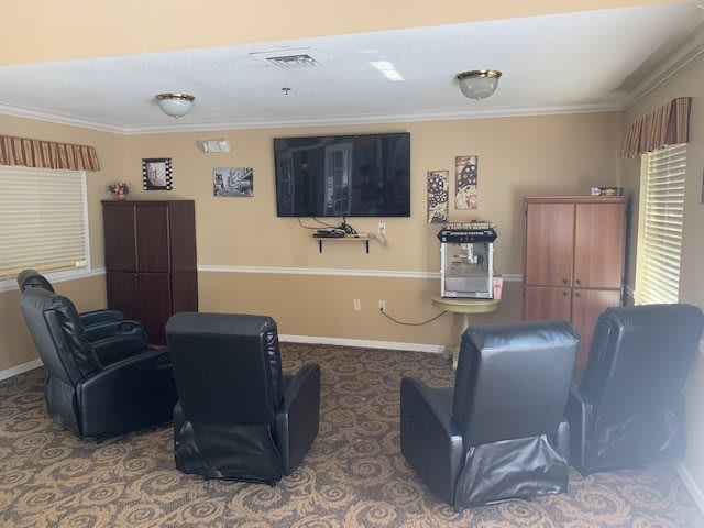 A cozy living space featuring recliner chairs and a wall-mounted television.